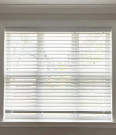 Cozy living room with freshly installed wooden blinds filtering soft sunlight.
