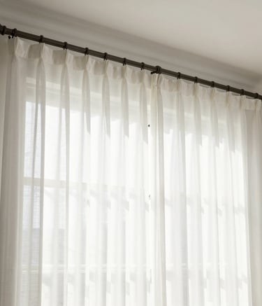 Bedroom window with stylish blackout curtains drawn halfway.