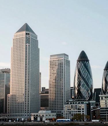 A wide-angle professional photograph of the Canary Wharf financial district in London, United Kingdom. The composition is clean and bright, utilizing soft white and slate blue tones to convey a sense of modern financial expertise.