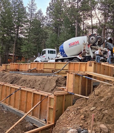 Workers preparing concrete wall forms for a structural residential foundation pour.