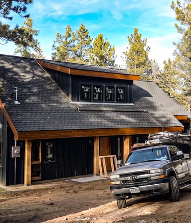 Modern detached garage with dark siding and wood trim built by Elk Valley Contractors in Evergreen, Colorado.