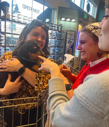 Smiling people holding a puppy for Edge Optics' community pet adoption event