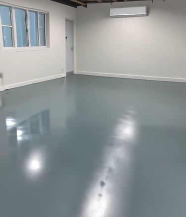 Painter applying fresh, vibrant paint to a residential floor in Terrassa