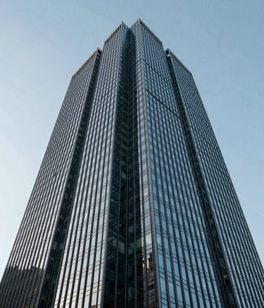 A low-angle photograph of an imposing glass and steel skyscraper against a clear sky, symbolizing institutional integrity and high-impact strategy. The lighting is crisp and modern, reflecting professional authority in a North American / International Business atmosphere. Palette colors include slate blue and dark navy.