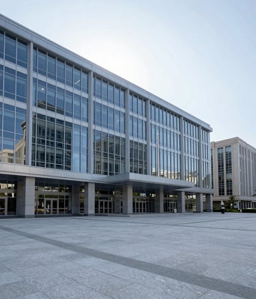 A wide shot of a clean, modern city government plaza under a bright sky. The architecture is contemporary with large glass panels reflecting light, conveying professional authority and stability in a North American / International Business context. Palette colors include light grey and steel blue.