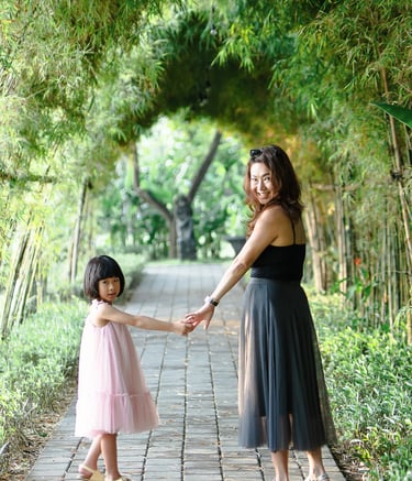 Mother and child walking together at Padma Resort Legian Bali surrounded by tropical garden atmosphere.