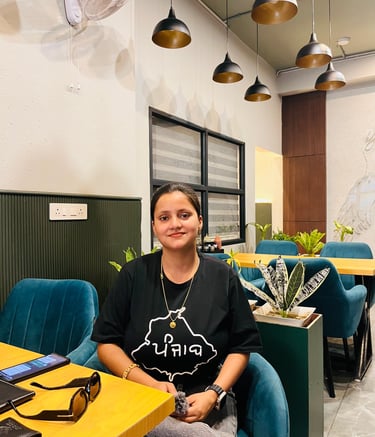 a woman sitting at a table with a laptop