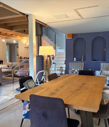 Salle a manger avec table en bois, poutre et arche