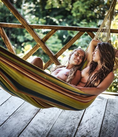 Dos amigas mirándose mientras descansan en una hamaca