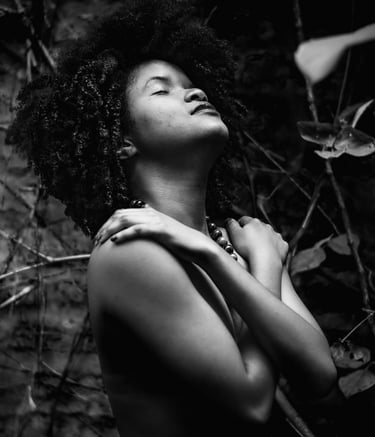Mujer afro abrazandose con los ojos cerrados, en su rostro se ve plenitud