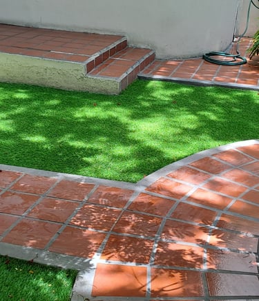 Jardín residencial con césped sintético instalado por Pasto Sintético Aldrete