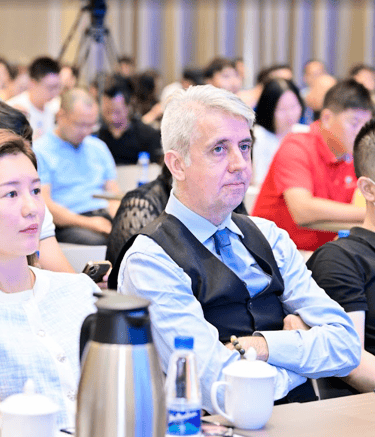 Professional attendees listening intently at a business conference seminar in an auditorium.