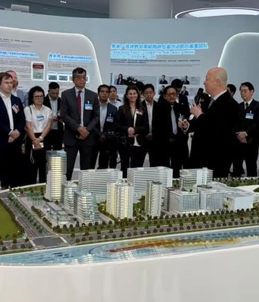 A group of business professionals viewing a detailed architectural 3D scale model of a modern city development.