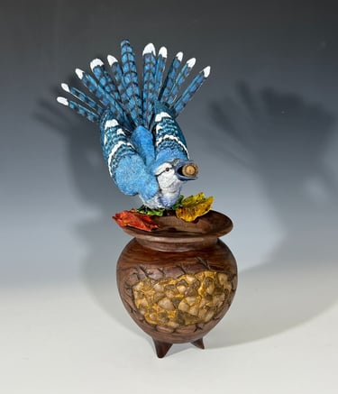 a blue bird sitting on top of a wooden bowl