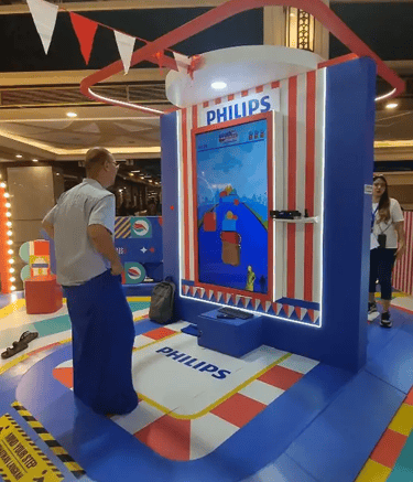 Man playing digital sack race game using Kinect motion sensor at mall activation