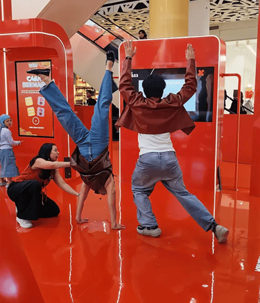 Participant jumping to match the body silhouette in Pocky Hole in the Wall game