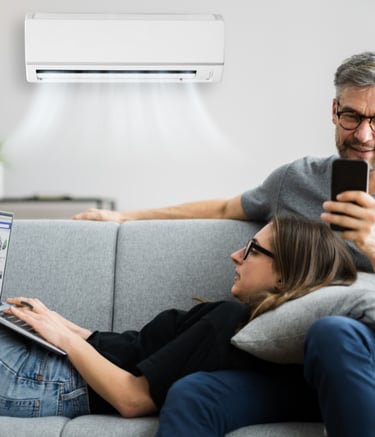 casal no sofa tranquilo controlando a temperatura do ar condicionado pelo celular