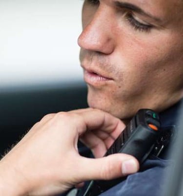 Person in vehicle using their microphone/speaker connected to their portable radio