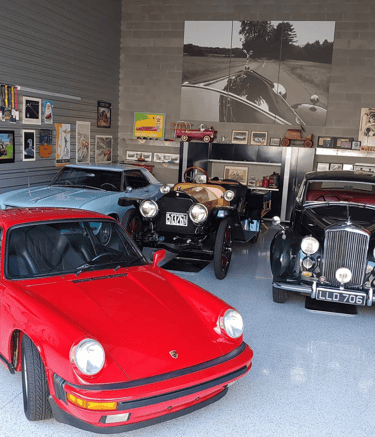 Personal car collection, stored in a warehouse, garage, or hanger.