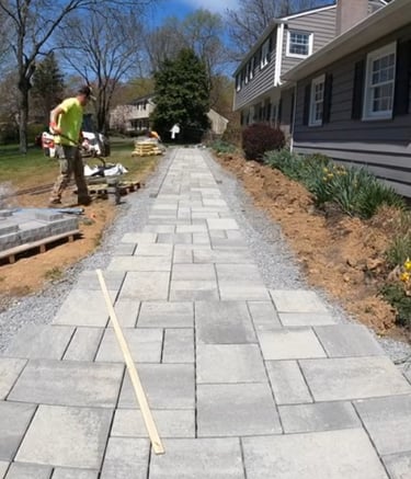 a paver project with grey paver stones being organized for a home walkway