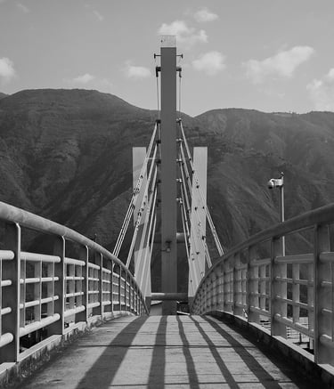 a suspension bridge leading towards some mountains