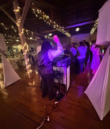 a dj spinning around a dj booth at a wedding