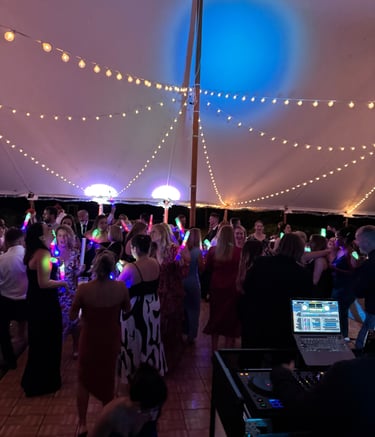 a group of people standing around a dj booth