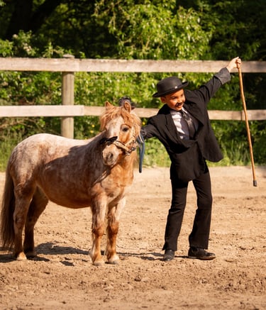 a girl in a suit and hat standing next to a horse