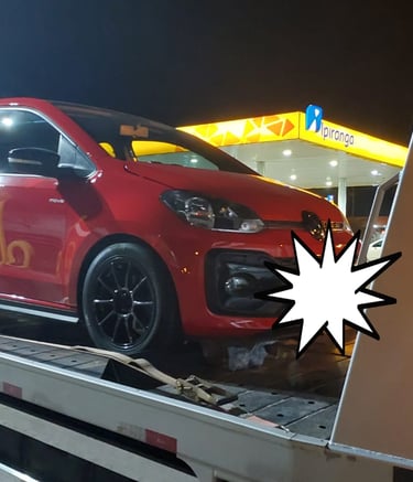 Guincho no posto carregando carro vermelho