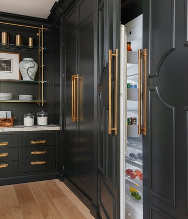 a kitchen with black cabinets and gold accents