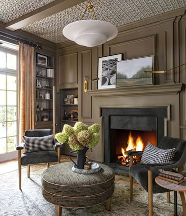 a living room with a fireplace and chairs
