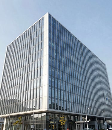 A wide-angle professional photograph of the Roni Door Legacy corporate headquarters, a sleek modern glass building under bright daylight. The scene represents international global business with high-end architecture in shades of white and pale blue.