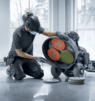 Changing grinding pads to reduce abrasion to hone floors for a smoother surface.