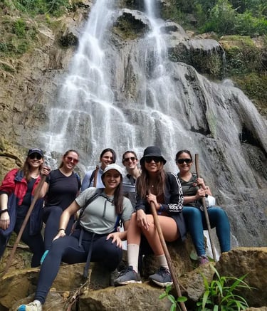 a group of people standing around a waterfall