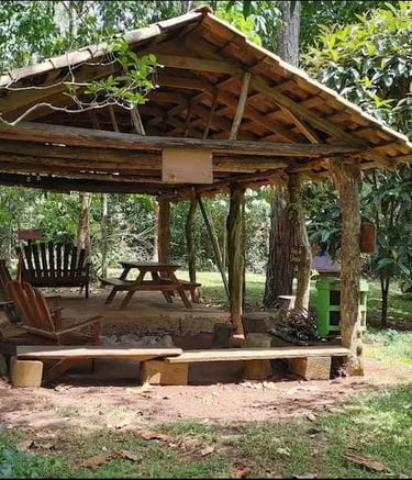 a wooden gazeboar with a bench and chairs