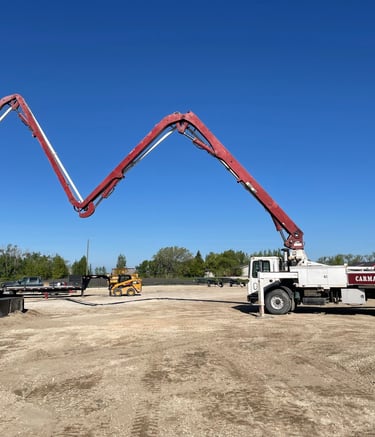 Concrete pump truck placing concrete at large construction site in Manitoba