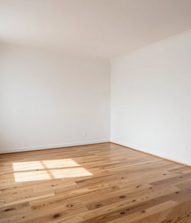 A wide-angle photography shot of a completely empty, sun-drenched apartment living room in Île-de-France with clean white walls and polished wooden floors, symbolizing a finished professional clearing job, natural lighting, high-end and minimalist feel.