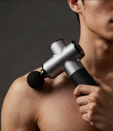 Cinematic photography of a male athlete's upper body from the chest up, using a premium recovery massage gun on his shoulder. Low-key lighting with Gold and Deep Black tones. Dark Charcoal studio setting, Global / Performance Athletics.