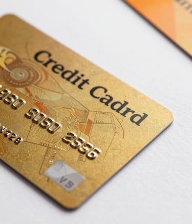A close-up of a high-end Indian credit card resting on a clean white surface with an orange accent element nearby, professional studio photography, reflecting a premium financial aesthetic.