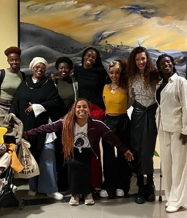 Un grupo de mujeres afro posando para la foto con un bebe en un carrito