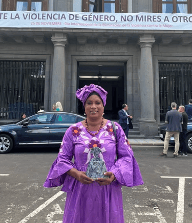 una mujer con un vestido morado sujetando un premio con las dos manos