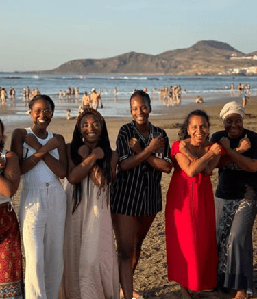 un grupo de mujeres afro posando para la foto en una playa