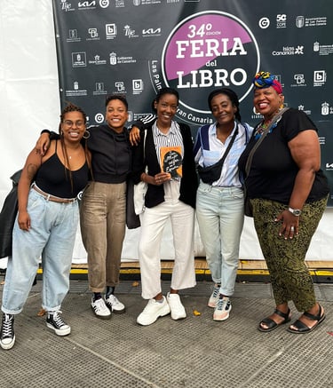 Un grupo de mujeres afro de pie frente a una pancarta posando para la foto