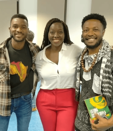 Dos hombres afros y una mujer afro de pie posando para la foto