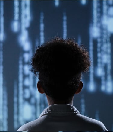 A software developer views falling digital code and binary data on a large screen.