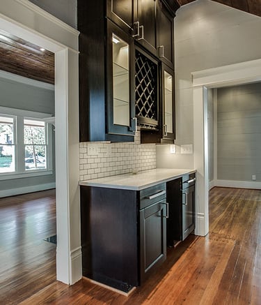 Home interior featuring dark wood cabinets, white subway tile backsplash, and hardwood floors.