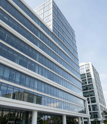 A high-resolution, wide-angle faceless architectural shot of a modern North American medical campus with glass facades and clean Crisp White lines, reflecting a high-authority government facility aesthetic under a clear sky.