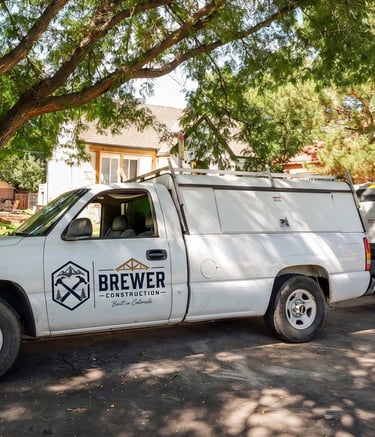 Dennis Brewer Construction work truck parked on a residential street in Denver.