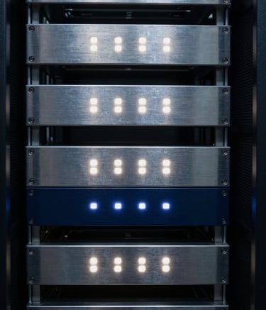 An abstract close-up of a server room with glowing deep navy and soft white LED lights reflecting off brushed metal surfaces. The composition focuses on symmetry and clean lines, symbolizing robust engineering and secure data infrastructure.