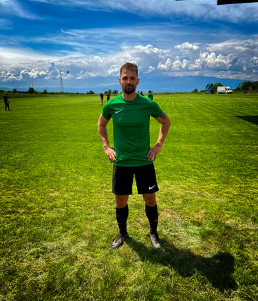 a man in a green shirt and black shorts standing in a field